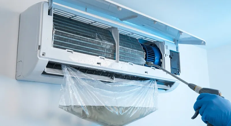 Indoor air conditioner opened for deep cleaning with the evaporator coil being washed